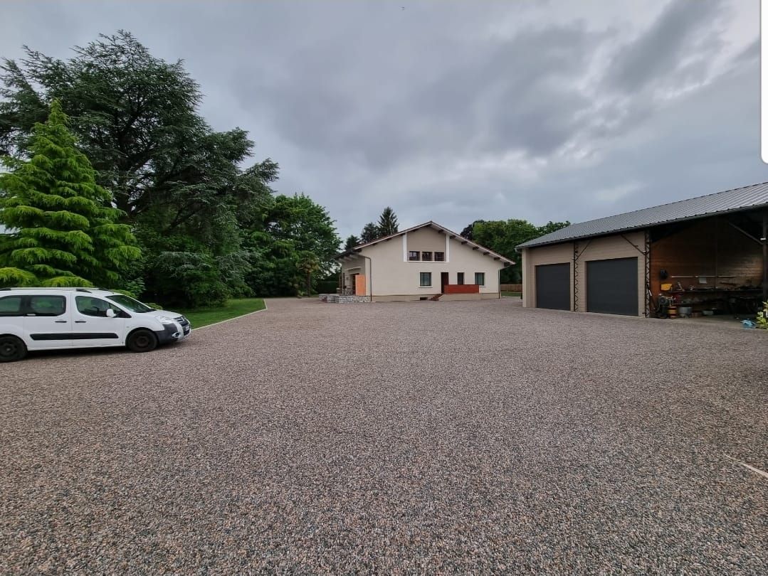 Cour aménagée en gravier avec garages après terrassement
