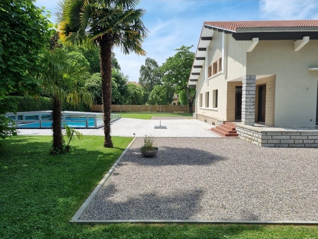 Jardin aménagé avec terrasse en gravier et piscine rénovée